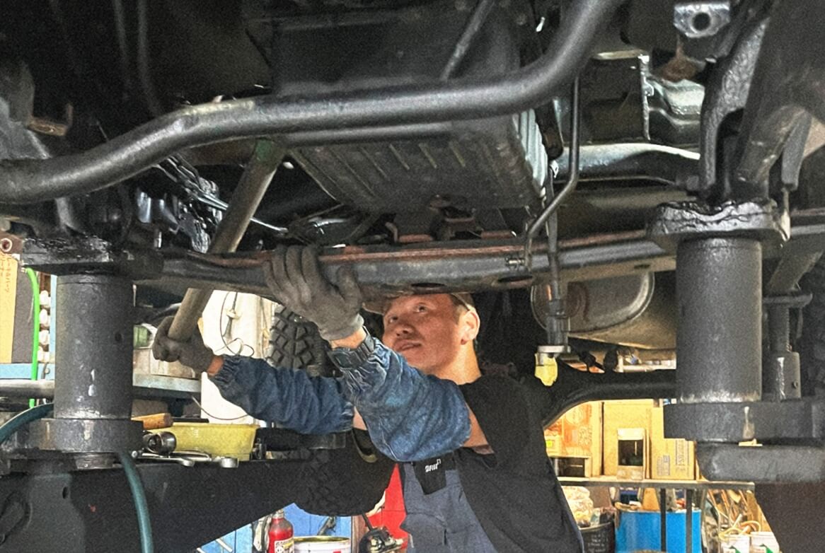 車両下部を整備するスタッフ