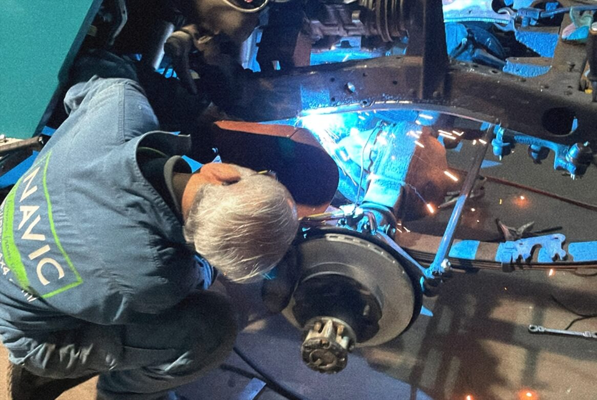 車両に対して製作作業を行うスタッフ